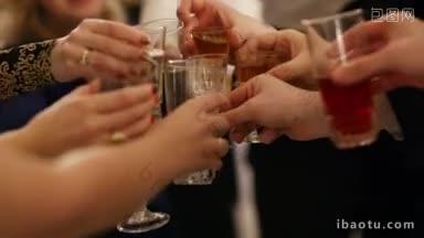 一群人在庆祝活动中碰杯庆祝，近距离观看他们的手